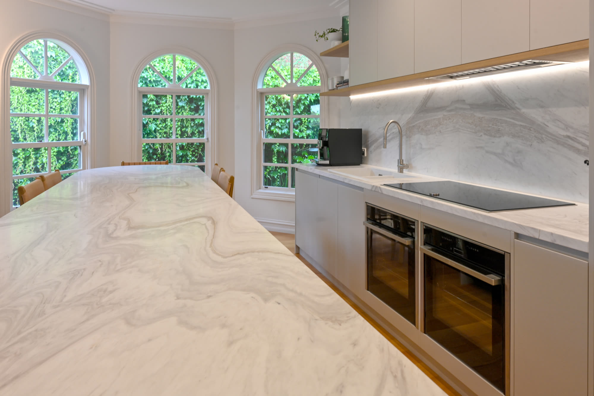 Blue island kitchen with marble benchtop and arched windows