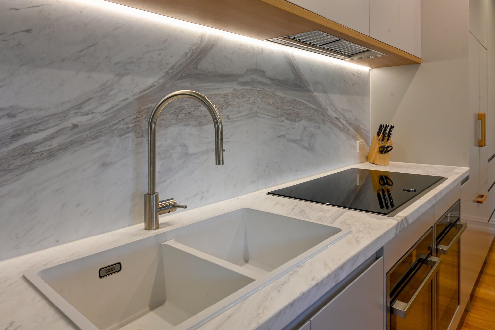 Marble benchtop, undermount sink and induction cooktop detail